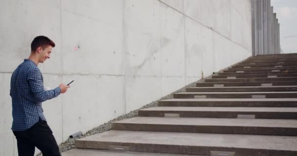 Joven usando un teléfono al aire libre — Vídeos de Stock