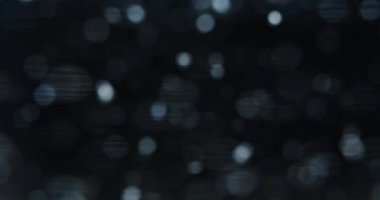 Gece ışıklarının koyu bokeh 'ini hareket ettiriyor.