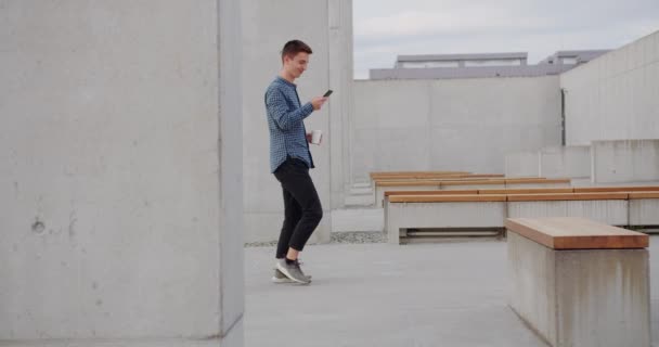 Młody człowiek korzystający z telefonu na zewnątrz — Wideo stockowe