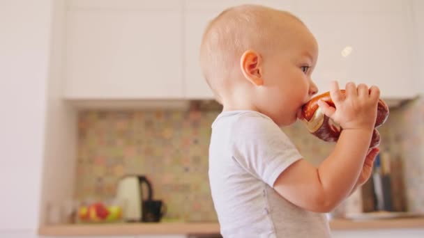 Малыш ест тесто на кухне — стоковое видео