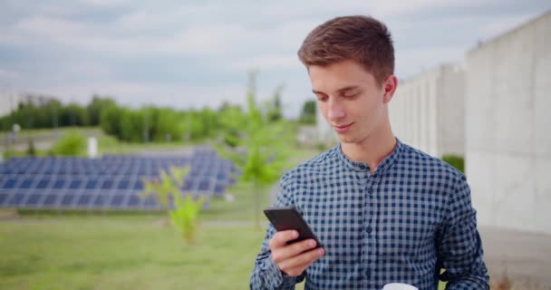 Jongeman met behulp van een telefoon buiten — Stockvideo