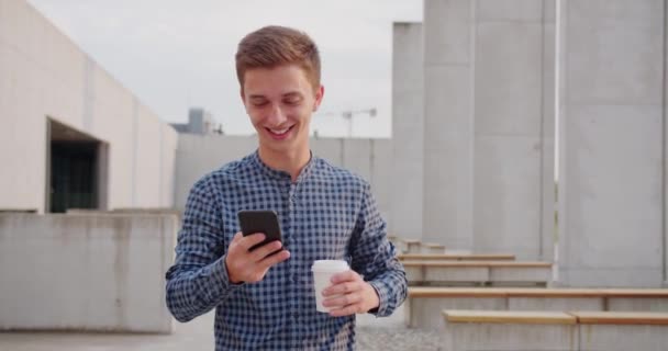 Joven usando un teléfono al aire libre — Vídeo de stock