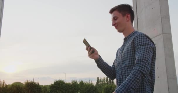Joven usando un teléfono al aire libre — Vídeo de stock