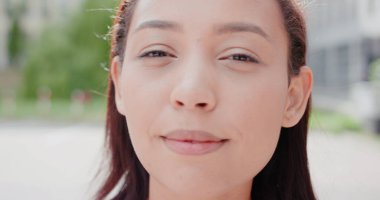 Açık havada gülümseyen esmer bayan.