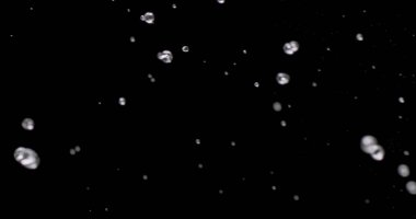 Küçük su damlacıkları siyah arkaplandan aşağı düşüyor.