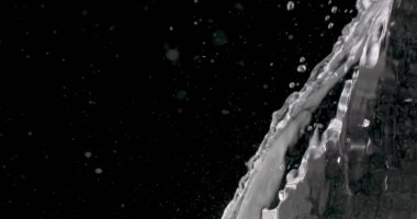 Su siyah bir arkaplana doğru atılıyor.