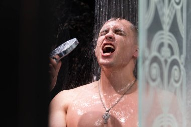 Adam duşta şarkı söyledi. Karanlık duvarlarile Duş