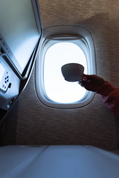 Vrouwen hand met een koffie in het vliegtuig — Stockfoto