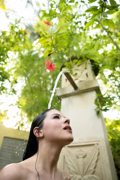 A young girl is taking a shower outdoors. — Stockfoto