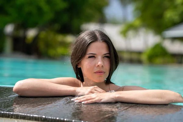 Ung flicka på kanten av poolen. Suddig bakgrund Stockbild