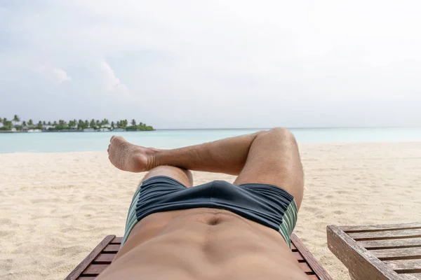 Розслабся на пляжі. В кадрі нижнього тіла хлопця . Стокова Картинка