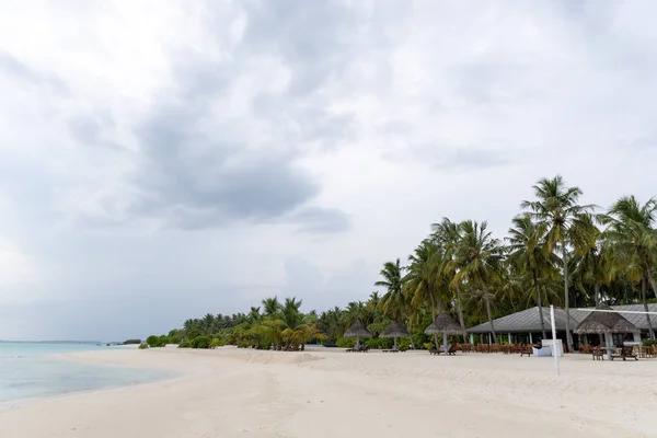 Tropikalna plaża na Malediwach z kilkoma palmami i błękitną laguną — Zdjęcie stockowe