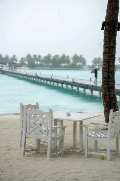 White table restaurant on the beach. The rainy season has begun — Zdjęcie stockowe