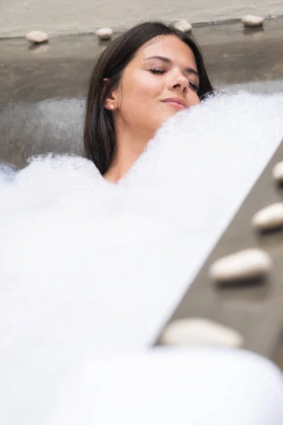 Un verdadero relax para una chica moderna. Hermosa morena toma un baño con espuma . —  Fotos de Stock