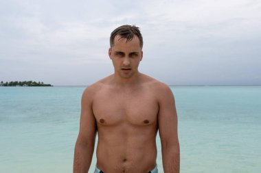 Güçlü adam denizi terk etti ve kameraya poz ver.