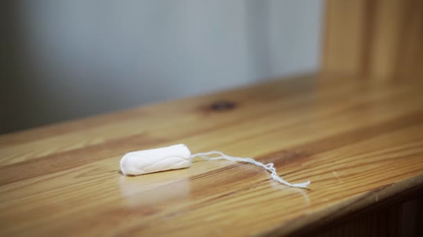 Flickan plockar upp en Tampon, som ligger på en hylla. Kvinnlig hand tar en vit pinne. — Stockvideo