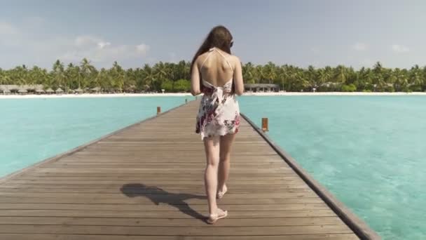 La donna sta camminando su un ponte di legno. Intorno alle isole tropicali e alle acque turchesi — Video Stock