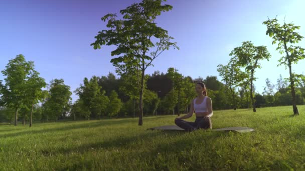 Young woman yoga outdoors keep calm and meditates while practicing yoga to explore the inner peace. — Stock Video