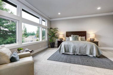 Büyük pencereler ve gri duvarlar ile açık modern yatak odası iç