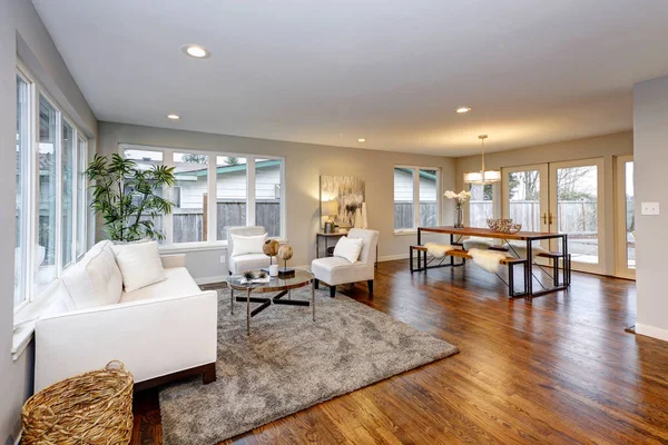 Spacious living area and dining room with lots of natural light and polished hardwood floor.