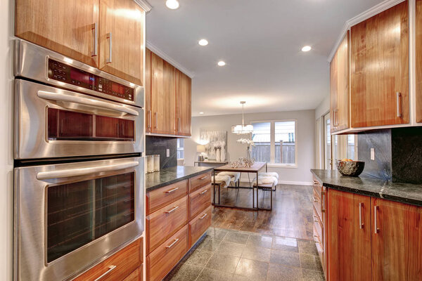 Роскошная кухонная комната с газовой плитой, деревянными шкафами и стальными шкафами
. 