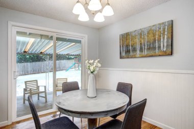 Kahvaltı köşesi ile yuvarlak beyaz yıkanmış tablo ve veranda yedeklemek için cam kapı.