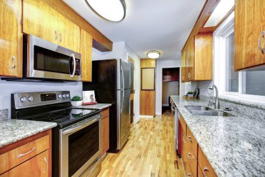 Doğal ahşap dolapları mutfak iç ada ve siyah buzdolabı.