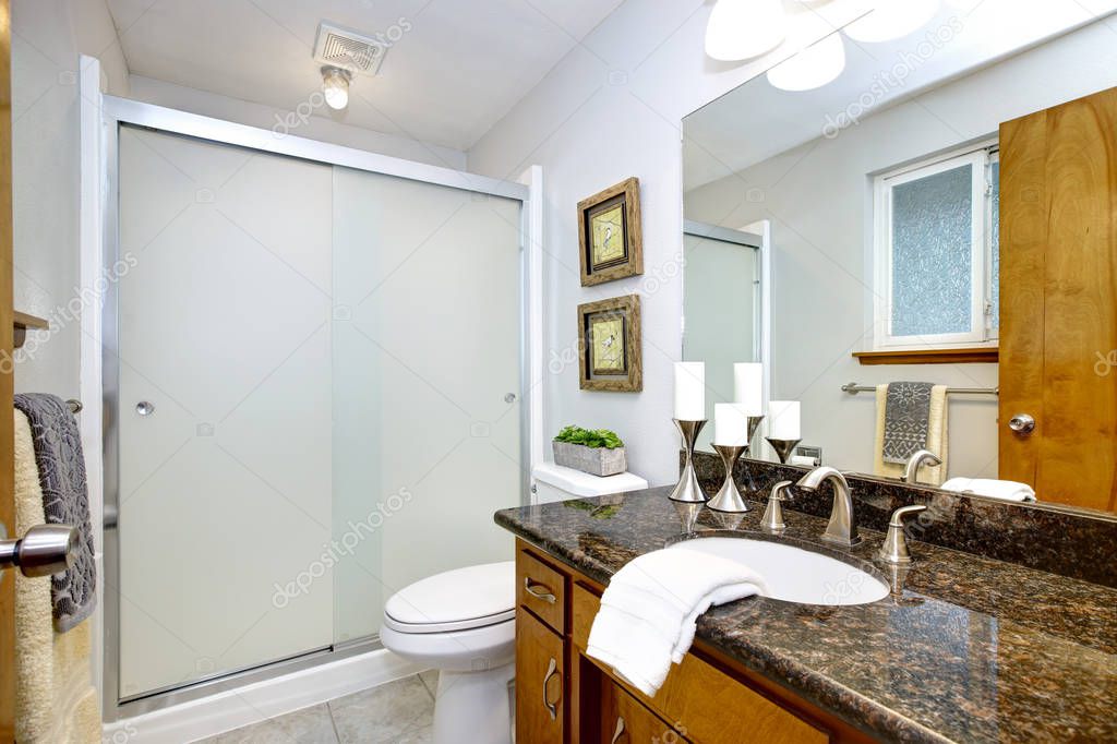 Remodeled bathroom with granite counter top vanity and glass shower