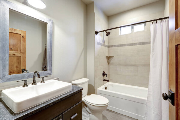 White and fresh bathroom interior with a rectangular vessel sink and ivory subway tile shower surround .