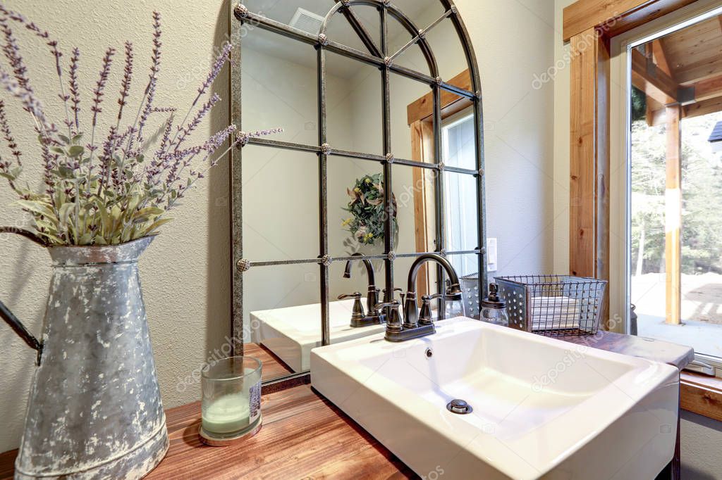 Fantastic bathroom boasts a country style washstand adorned with iron cage mirror 