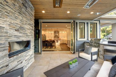 Lüks modern ev dış taş şömine ve rahat mobilya kapalı veranda ile