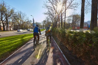 Şehirde bir bisikletçi bisiklet yol boyunca hareket ediyor. Ulaşım çevre dostu modu. Arkadan görüntüleyin. Sabit hız bisiklet