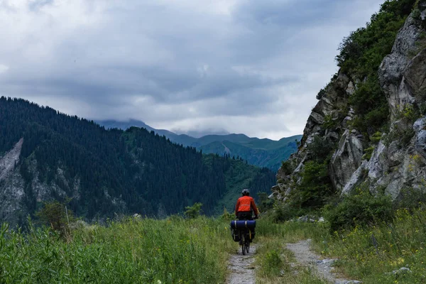 Bicycle tourism. A man is riding a bicycle in the mountains. Mountains of Tien Shan. Kazakhstan