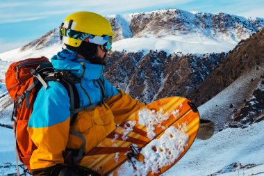 Bir snowboard dağlarda onun elinde olan bir adam. Bir yamaç düşünüyor. Dağları, Kırgızistan