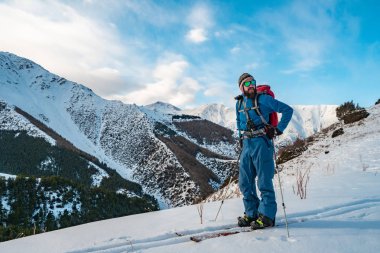 A man is engaged in ski touring on splitboarding. Sunrise in the mountains. Kyrgyzstan clipart