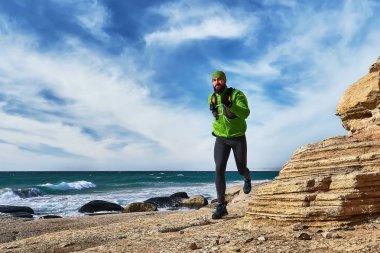 Sporcu adam deniz kıyısı güneşli bir günde çalışır. İz çalışan. Mangistav Yarımadası. Kazakistan