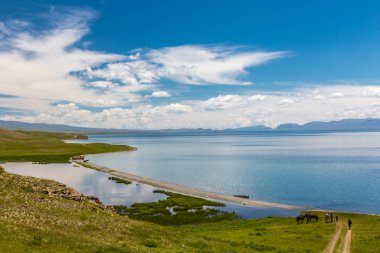 Bir adam muhteşem bir dağ gölüne yokuş aşağı bisiklet sürmek.