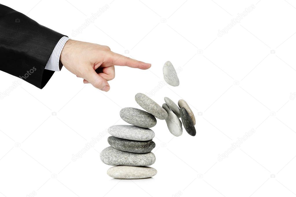 male hand pushing a stack of stones