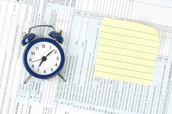 çalar saat ve ABD vergi form üzerindeki sarı Not