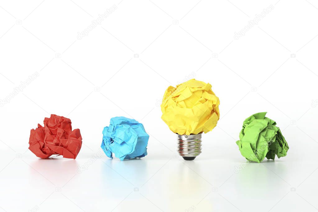 crumpled paper light bulb among other crumpled paper balls, idea or different concept