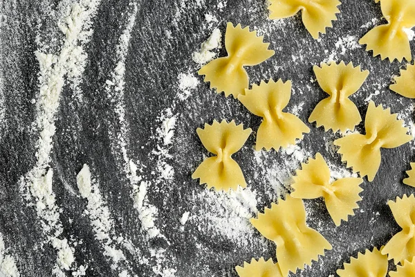 Massa Farfalle Crua Com Farinha Textura Pedra Preta — Fotografia de Stock