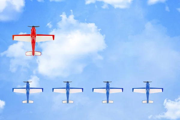 red plane leading a formation of smaller planes on paper surface with clouds, leadership concept