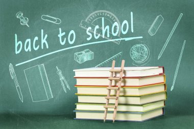 kalem merdiven üzerinde kitap yeşil kara tahta karşı yığını ile okul kavramı geri