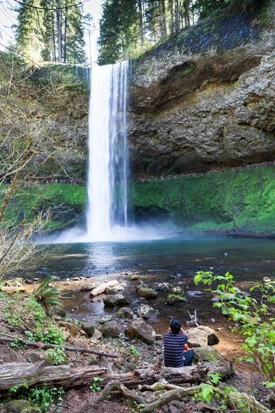 İnsanlar rock cliff falls gider yürüyüş iz üzerinde dururken Güney Şelalesi gümüş Falls State Park, Oregon'da bir cep telefonu resim çekmek bir adam.