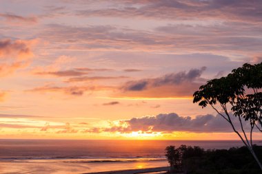 Bulutlar ve gökyüzü canlı renkleri arkasında görülen doğal güzellikleri güzel bir görüntü bırakarak ufuk güneş batmadan farklı bir dağ Uvita, Kosta Rika üst formu