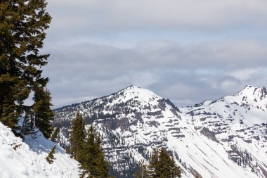 Bekçi tepe soldaki ve sağdaki Hillman tepe hala erken bahar Oregon Krater Gölü Milli Parkı, karla kaplı.