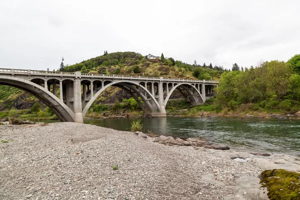 Μια Τσιμεντένια Γέφυρα Αψίδων Που Εκτείνονται Πέρα Από Πράσινα Νερά — Φωτογραφία Αρχείου