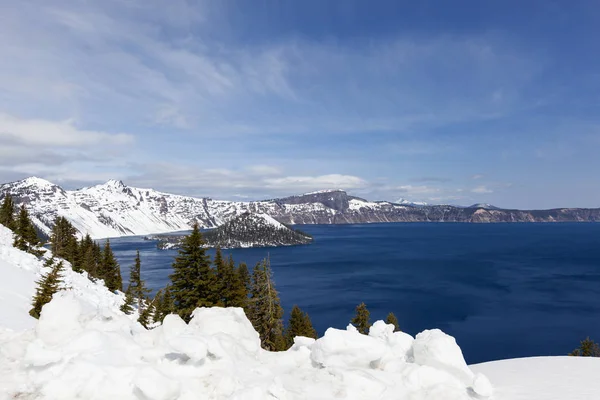 深蓝色的海水环绕着巫师岛 明亮的白雪覆盖着俄勒冈州火山口湖畔 — 图库照片