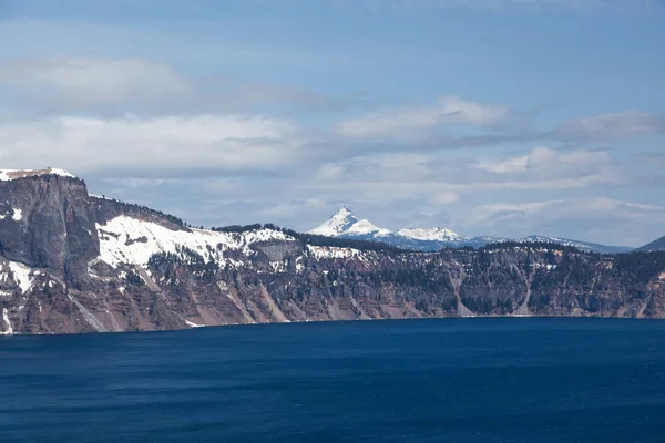 先のとがったマウント Thielson は青い水とオレゴン州のクレーターレイク国立公園の険しい崖を越えて遠くにスティック — ストック写真