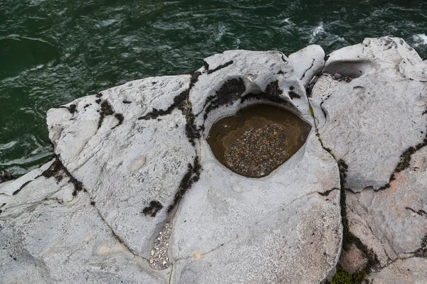 上无赖河岸边的火山岩 被旋转的砾石雕刻成洞 — 图库照片